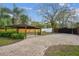 Long stone driveway leading to a carport and gated entrance, offering ample parking and security at 14333 Lake Magdalene Blvd, Tampa, FL 33618