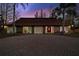 Charming home with a red front door and a circular stone driveway, creating a welcoming entrance at 14333 Lake Magdalene Blvd, Tampa, FL 33618