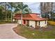 Charming home with a unique roof, stone accents, and a circular brick driveway at 14333 Lake Magdalene Blvd, Tampa, FL 33618