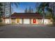 Charming home featuring a circular driveway, stone accents, a brown roof, and a vibrant red front door at 14333 Lake Magdalene Blvd, Tampa, FL 33618