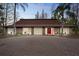 Home featuring a circular brick driveway, red door, and stone facade accents at 14333 Lake Magdalene Blvd, Tampa, FL 33618