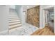 Hallway with stairs, stone accent wall, tile floors, and wooden floors at 14333 Lake Magdalene Blvd, Tampa, FL 33618