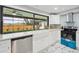 Bright white kitchen with stainless steel appliances, a farmhouse sink, and views of the backyard at 14333 Lake Magdalene Blvd, Tampa, FL 33618