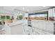 White kitchen featuring marble countertops and floors, stainless steel appliances, and recessed lighting at 14333 Lake Magdalene Blvd, Tampa, FL 33618