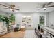 Spacious living room with ceiling fans, light hardwood floors, a built-in bookshelf, and neutral furniture at 14333 Lake Magdalene Blvd, Tampa, FL 33618
