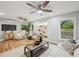 Airy living room with light hardwood floors, modern ceiling fans, built-in shelving, and ample natural light at 14333 Lake Magdalene Blvd, Tampa, FL 33618