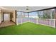 Enclosed patio with artificial grass and scenic views of the lake and surrounding trees at 14333 Lake Magdalene Blvd, Tampa, FL 33618