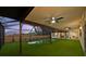 A screened-in pool area is turfed with artificial grass and a fence, creating a relaxing outdoor oasis at 14333 Lake Magdalene Blvd, Tampa, FL 33618