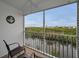 Screened balcony with seating provides peaceful views of the surrounding waterway and landscape at 14747 Seminole Trl, Seminole, FL 33776