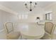 This dining area with seating for two is open to the living room and has a chandelier at 19111 Vista Bay Dr # 401, Indian Shores, FL 33785