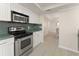 This kitchen features white cabinets, stainless appliances, and a green countertop backsplash at 19111 Vista Bay Dr # 401, Indian Shores, FL 33785