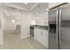 Open kitchen area with stainless steel appliances, green countertop, and views to the living and dining areas at 19111 Vista Bay Dr # 401, Indian Shores, FL 33785