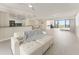 This open-concept living room connects to the kitchen with balcony access and neutral decor at 19111 Vista Bay Dr # 401, Indian Shores, FL 33785