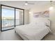 Bright main bedroom with a large bed, waterfront balcony, and modern pendant lighting at 19111 Vista Bay Dr # 401, Indian Shores, FL 33785