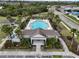 Aerial view of a beautiful community pool, clubhouse, and playground, lined with mature palm trees at 2007 Hawks View Dr, Ruskin, FL 33570