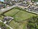 Aerial view of a fully fenced community dog park with green grass and mature trees at 2007 Hawks View Dr, Ruskin, FL 33570