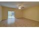 Inviting living room with tile flooring, a ceiling fan, and sliding glass doors that fill the space with natural light at 2007 Hawks View Dr, Ruskin, FL 33570