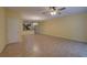 Spacious living room with tile flooring, a ceiling fan, and seamless flow to other living areas and a kitchen view at 2007 Hawks View Dr, Ruskin, FL 33570