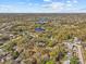 Expansive aerial view of a lush, residential area featuring mature trees, serene lakes, and charming homes under a bright, cloudy sky at 2207 Boxwood Way, Brandon, FL 33511