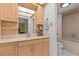 Bright bathroom featuring wood cabinets, a white sink, and a shower/tub combo with pink curtain at 2207 Boxwood Way, Brandon, FL 33511