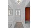 This entryway boasts a white door with decorative glass, a white console table, and tile floors that add to the appeal at 2207 Boxwood Way, Brandon, FL 33511