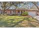 Charming brick home with a well-manicured lawn and mature trees providing shade at 2207 Boxwood Way, Brandon, FL 33511