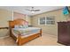 Comfortable main bedroom features carpet floors, a ceiling fan, and a wooden bed frame at 2207 Boxwood Way, Brandon, FL 33511