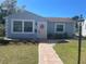 Charming single-story home with a brick walkway, pink door, and manicured front lawn at 2235 20Th St S, St Petersburg, FL 33712