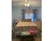 Comfortable bedroom with light blue walls, ceiling fan and a sunlit window at 2700 Bayshore Blvd # 2308, Dunedin, FL 34698