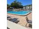 Inviting community pool surrounded by lounge chairs and palm trees at 2700 Bayshore Blvd # 2308, Dunedin, FL 34698