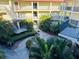 Lush courtyard view with mature landscaping, walkways, and multi-story buildings with balconies and stairwells at 2700 Bayshore Blvd # 2308, Dunedin, FL 34698
