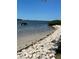 Scenic waterfront view with sandy beach, rocky shoreline, and a boat on the water at 2700 Bayshore Blvd # 2308, Dunedin, FL 34698