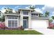 Beautiful one-story home with a blue front door, a white garage door, and tropical landscaping at 3813 109Th Street East, Palmetto, FL 34221