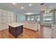 A kitchen area featuring white cabinets, an island with a sink, and wood flooring throughout at 3904 Executive Cir, Plant City, FL 33566