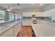 Kitchen area boasts white cabinets, island with sink, stainless appliances, and access to screened patio at 3904 Executive Cir, Plant City, FL 33566