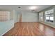 An empty living room area featuring wood floors, light walls, and natural lighting from three windows at 3904 Executive Cir, Plant City, FL 33566