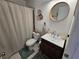 Bathroom featuring custom wood vanity, round mirror, and neutral shower curtain at 3934 37Th S St # 36, St Petersburg, FL 33711