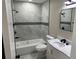 Renovated bathroom featuring modern tub, sleek fixtures, white marble vanity, and gray marble floor and wall tiles at 3934 Huntington Ne St, St Petersburg, FL 33703