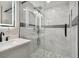Modern glass-enclosed shower featuring gray marble tile, hexagon mosaic accents, and a sleek black shower head at 3934 Huntington Ne St, St Petersburg, FL 33703
