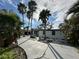 Attractive home exterior with palm trees, modern trim, stone landscaping, and a long concrete driveway at 3934 Huntington Ne St, St Petersburg, FL 33703