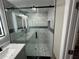 Modern bathroom shower with beautiful marble wall tiles, stylish mosaic accents, and frameless glass door at 3934 Huntington Ne St, St Petersburg, FL 33703
