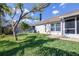 Well-maintained backyard with healthy green grass, mature trees, and a screened in patio at 4313 Brooke Dr, Valrico, FL 33594