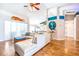 Bright living room with wood floors, fan, and modern white couch with view into kitchen at 4313 Brooke Dr, Valrico, FL 33594