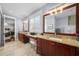 Bathroom boasting dual vanities, framed mirrors, granite countertops and tiled flooring at 4603 S Bartlett St, Tampa, FL 33611