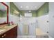 Bathroom featuring a glass shower with green tiled walls, and a granite vanity at 4603 S Bartlett St, Tampa, FL 33611