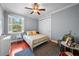 Cozy bedroom features a ceiling fan, a large window and a comfortable bed at 4603 S Bartlett St, Tampa, FL 33611