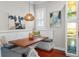 Charming breakfast nook with a rustic wooden table, bench seating and custom lighting fixture at 4603 S Bartlett St, Tampa, FL 33611