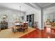 Open-concept dining room with hardwood floors, neutral decor, and a view to the living room at 4603 S Bartlett St, Tampa, FL 33611
