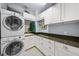 Efficient laundry room with stacked washer and dryer, ample counter space, and storage cabinets at 4603 S Bartlett St, Tampa, FL 33611