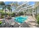 Stunning pool area with a fire pit, comfortable seating, and a fully screened enclosure at 4603 S Bartlett St, Tampa, FL 33611